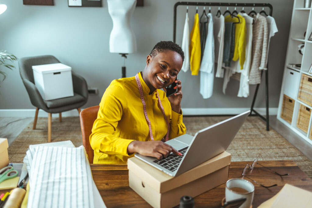 Business owners need websites that convert. Business woman in yellow shirt looks at orders on her website.